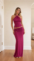 Model wearing fuchsia halter top and maxi skirt set from front
