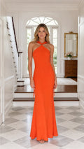 Front view of model wearing orange halter neck maxi dress