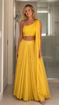 Front view of model wearing yellow one-shoulder crop top and pleated maxi skirt set