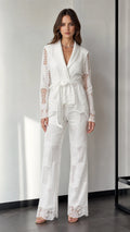 Front view of woman wearing white lace blazer and wide-leg pants set