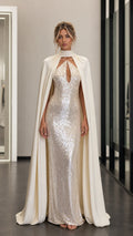 Front view of model wearing champagne sequin evening dress with attached cape