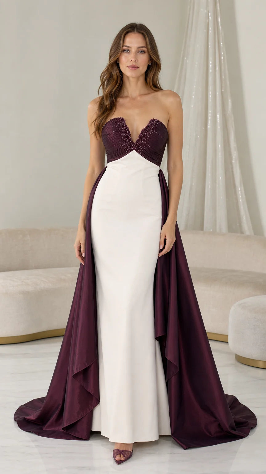 Front view of burgundy and white strapless evening dress with over-skirt train