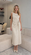 Front view of cream polka dot midi dress with waist tie