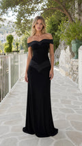Model wearing black off-the-shoulder evening maxi dress from the front