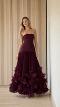 Front view of woman wearing burgundy strapless pleated ruffle evening gown