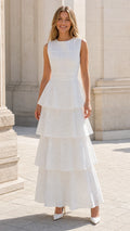 Front view of woman wearing white tiered eyelet maxi dress