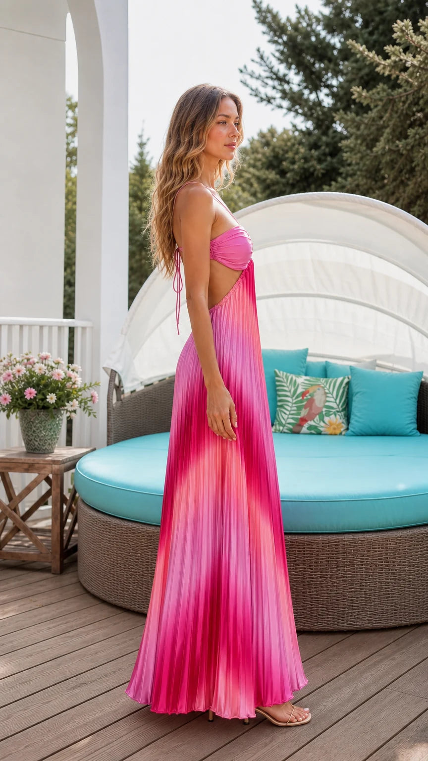 Side profile of model in pink ombre pleated maxi dress on resort deck