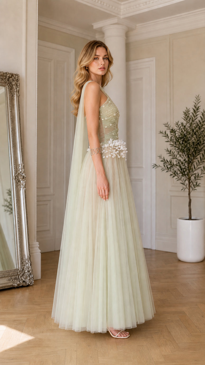 Side profile of sage green halter formal dress showing flowing shoulder drape and A-line silhouette