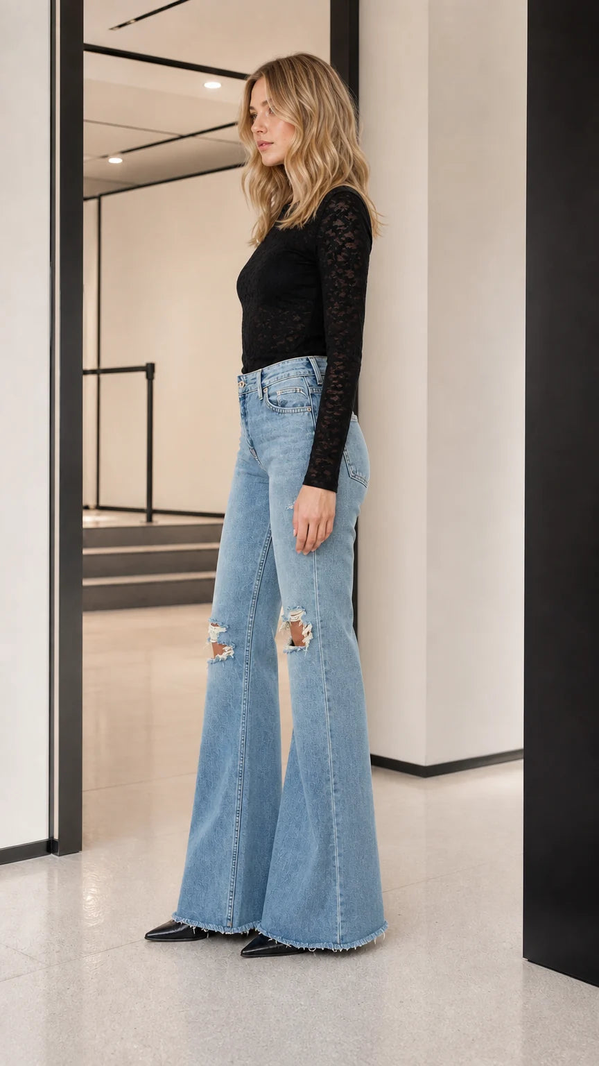 Model wearing black long-sleeve sheer lace top, side profile view