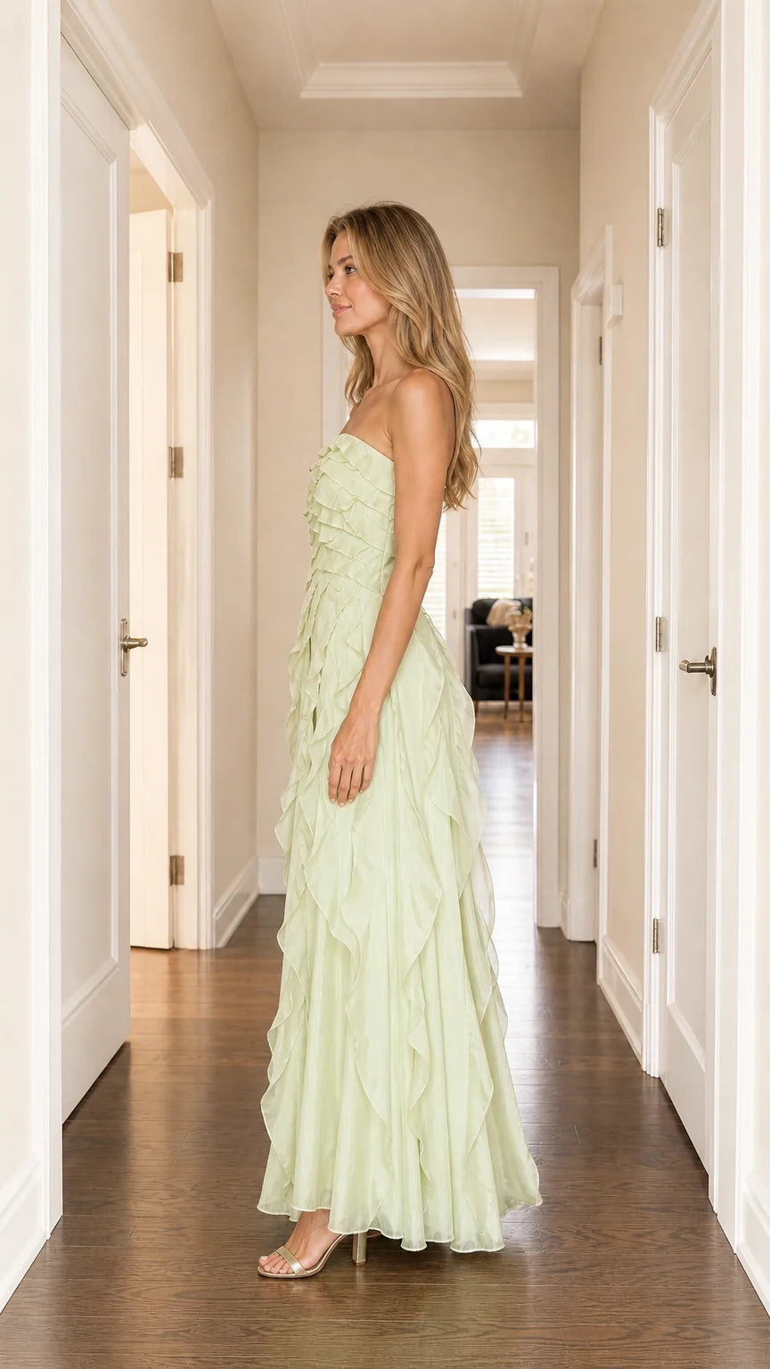 Model wearing sage green strapless ruffled maxi dress, side view