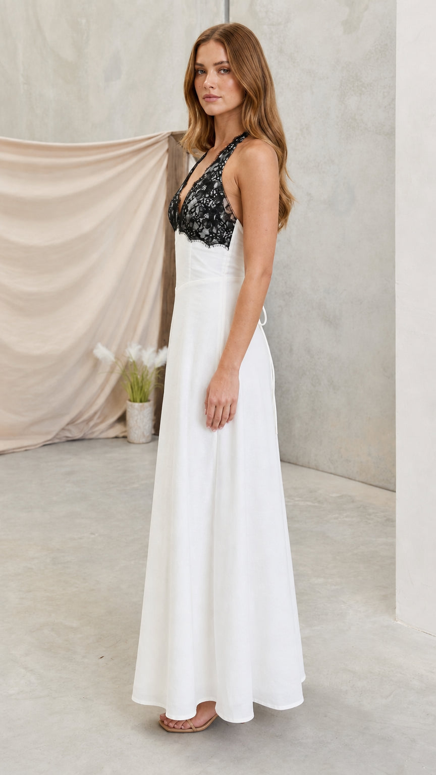 Model wearing white lace halter maxi dress side angle view