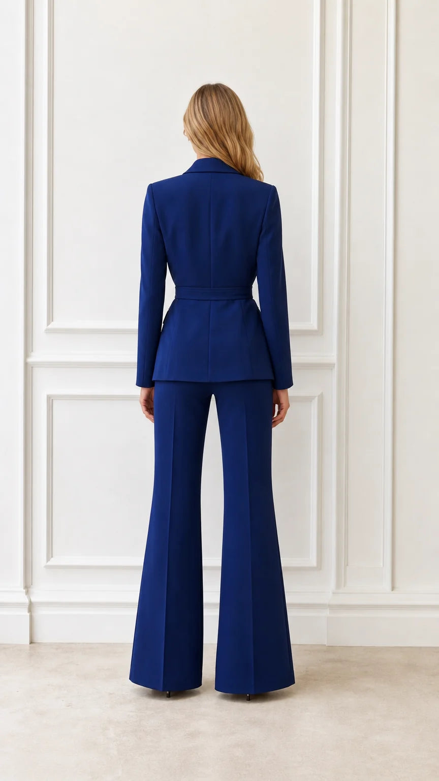 Back view of woman wearing royal blue suit set with flared trousers