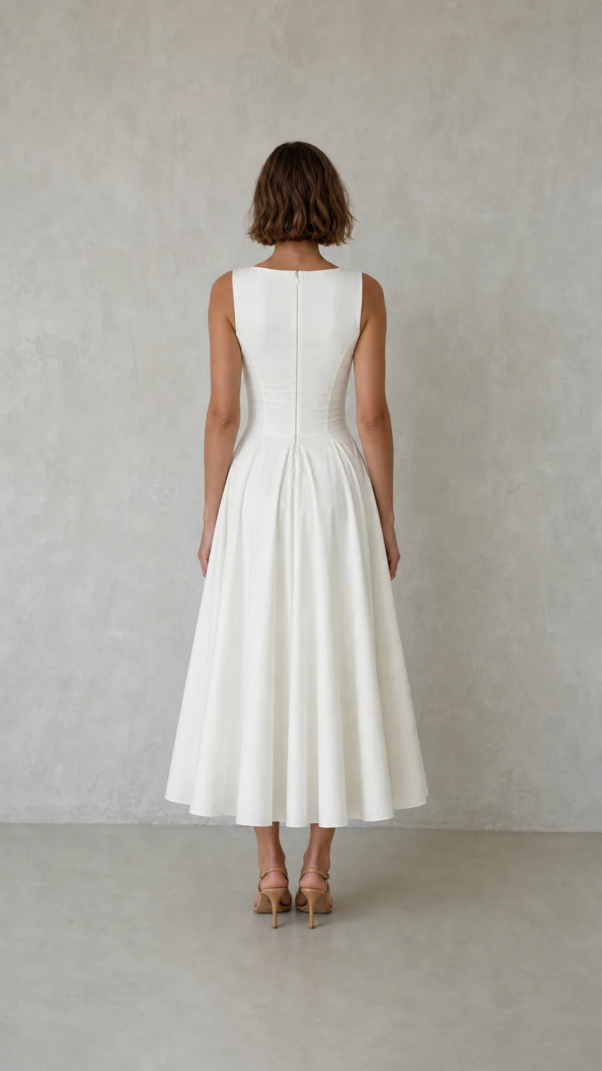 Back view of woman wearing white pleated dress