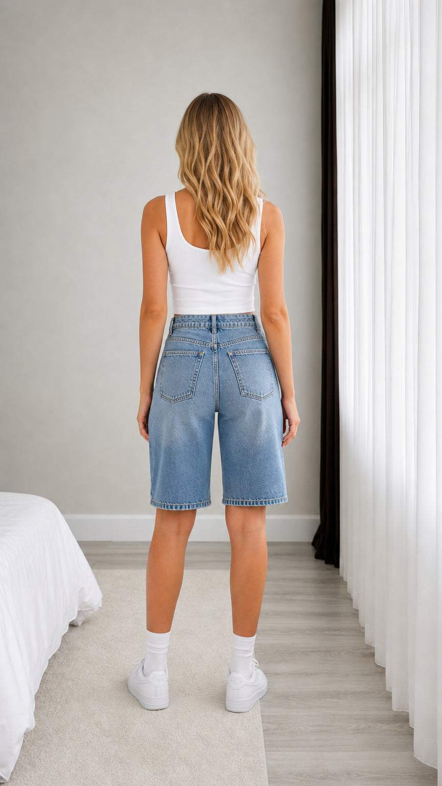 Back view of model wearing Light Blue denim Bermuda shorts with patch pockets