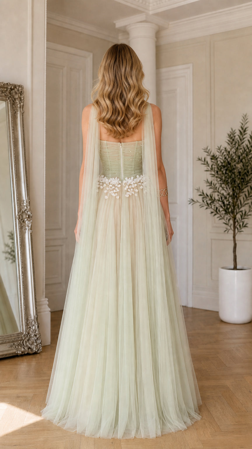 Back view of sage green tulle evening gown highlighting back neckline and cascading shoulder streamers