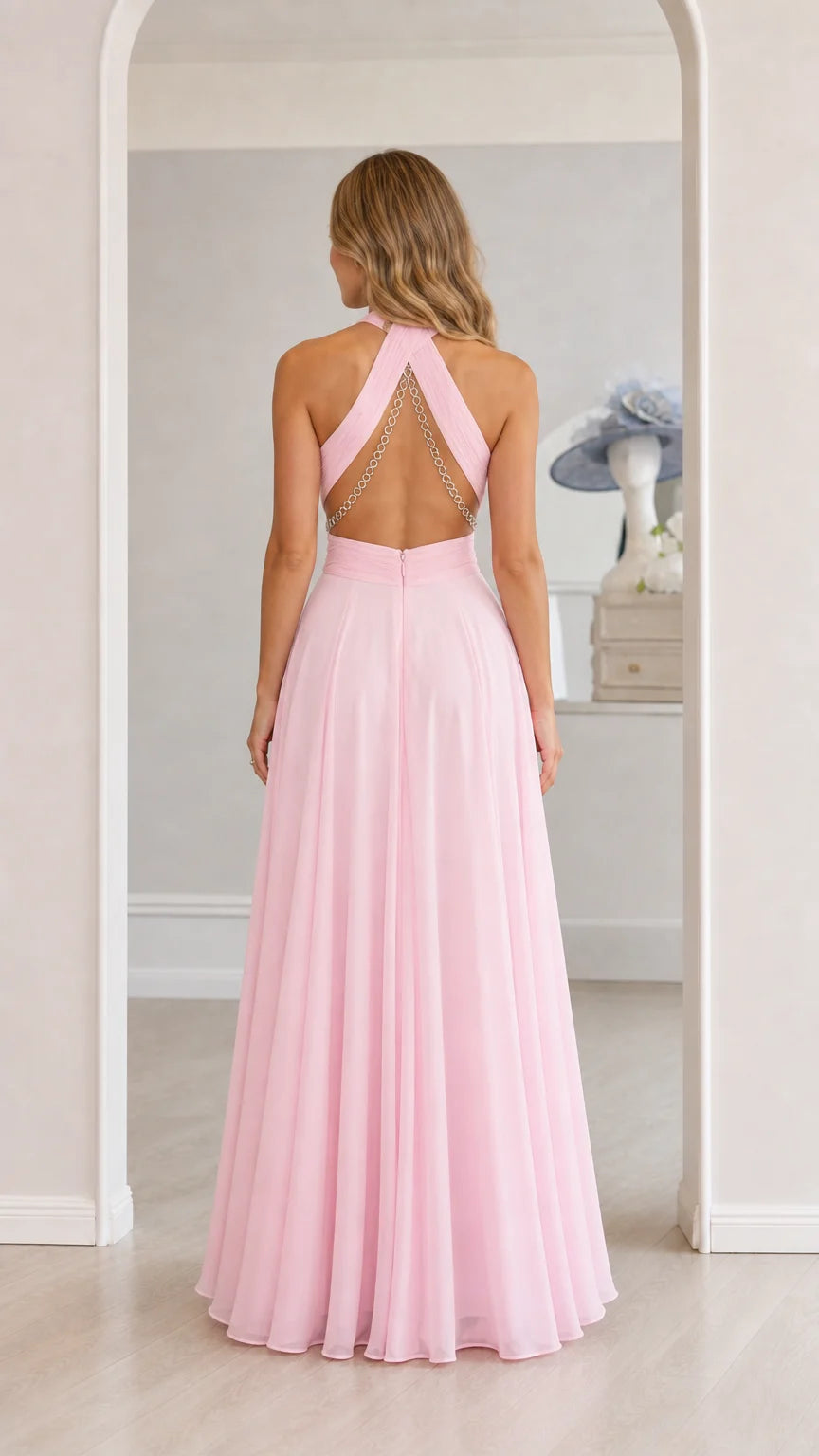 Model wearing pink chiffon halter maxi dress showcasing open back, back view