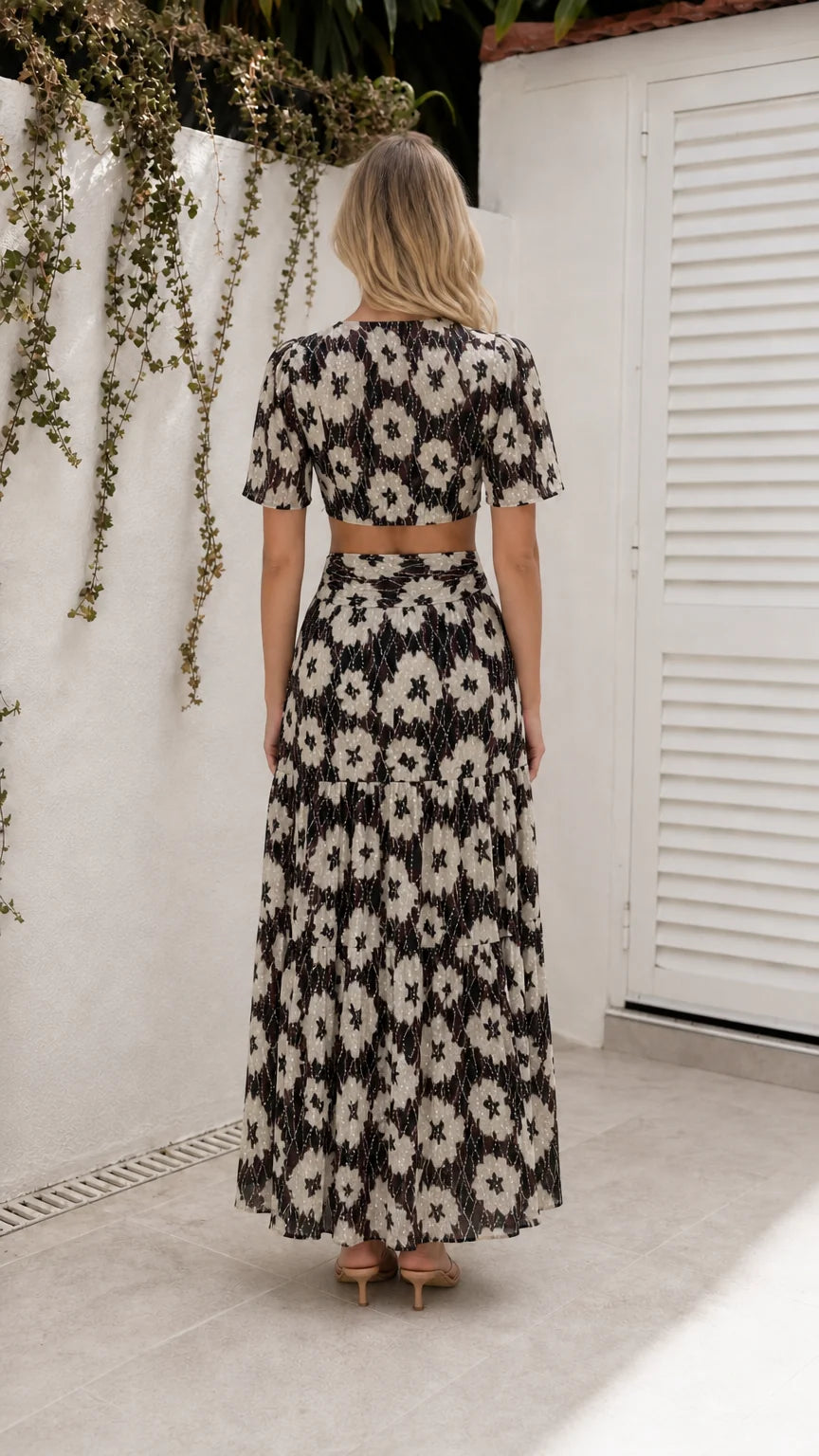 Back view of model wearing black floral cutout maxi dress