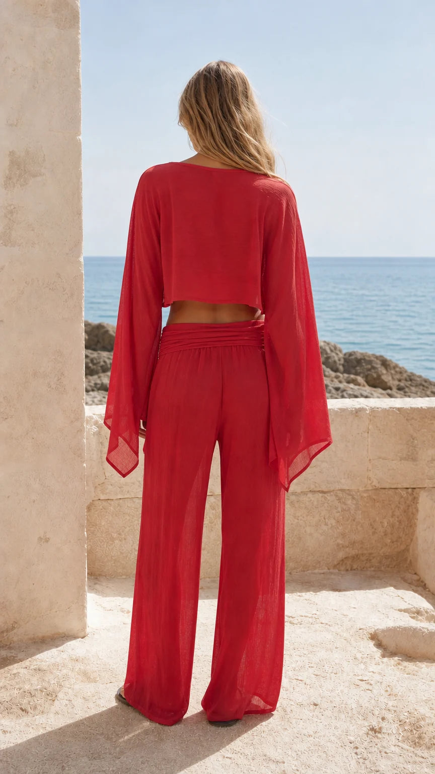 Back view of woman wearing red matching crop top and trousers