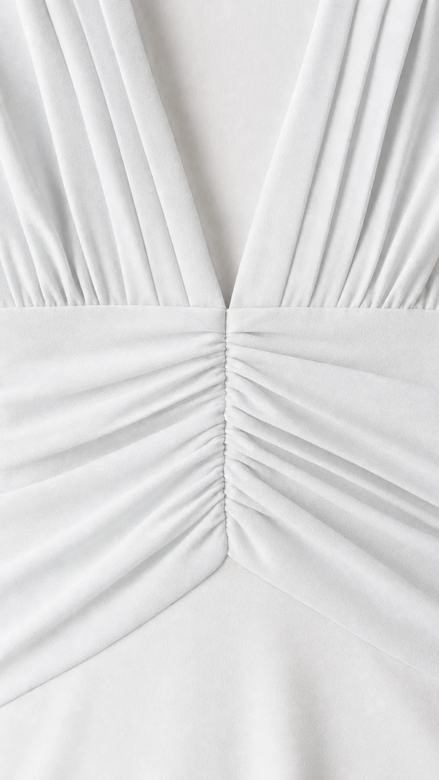 Close-up detail of pleated V-neck and ruched waist on white dress