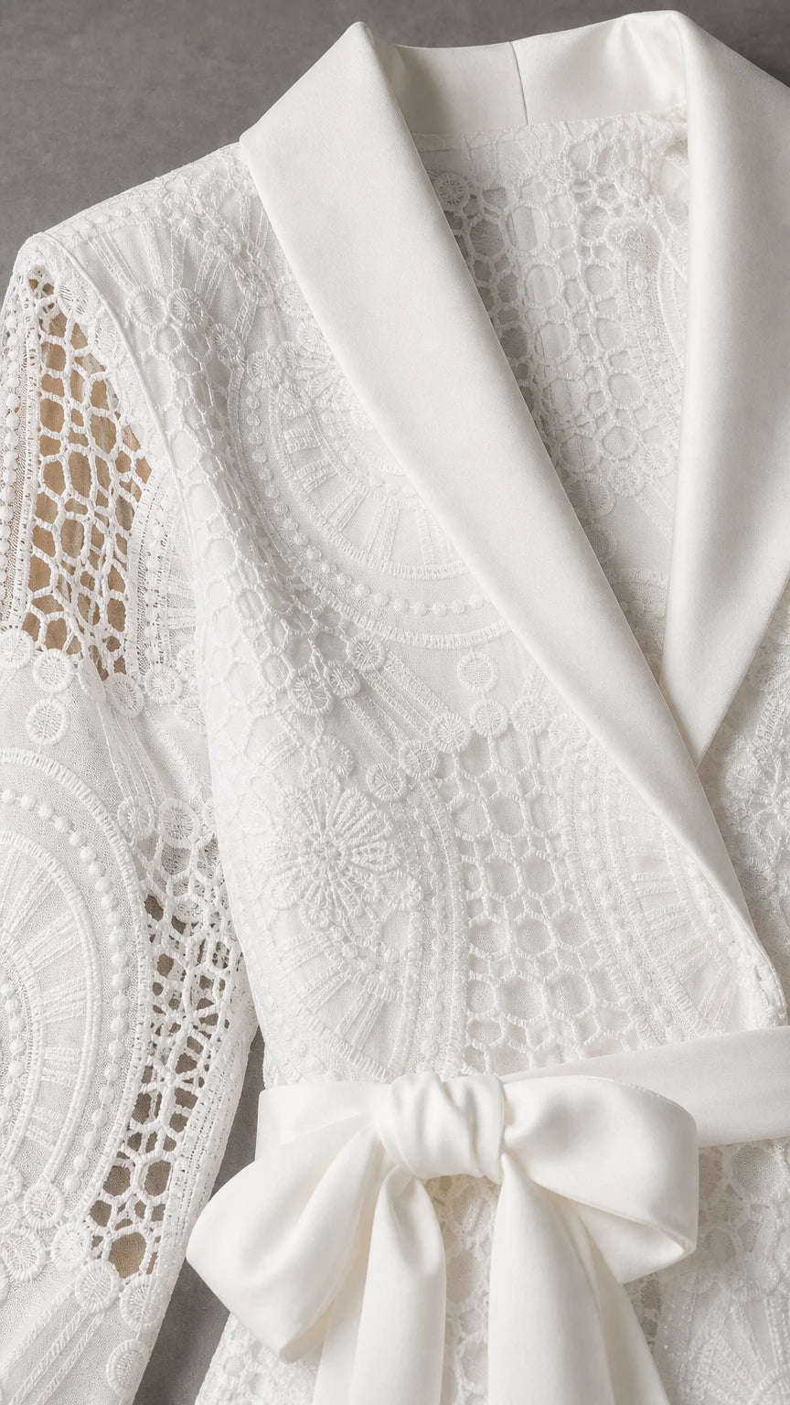 Close-up detail of white satin shawl collar and lace texture