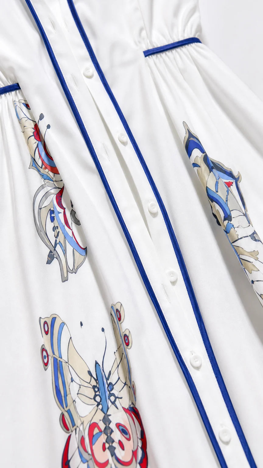 Close-up detail of button placket and butterfly print on white dress