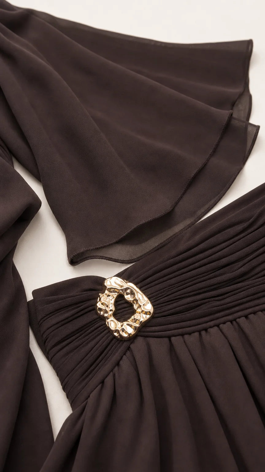 Close-up detail of the wide bell sleeves and ruched waistband with metallic buckle