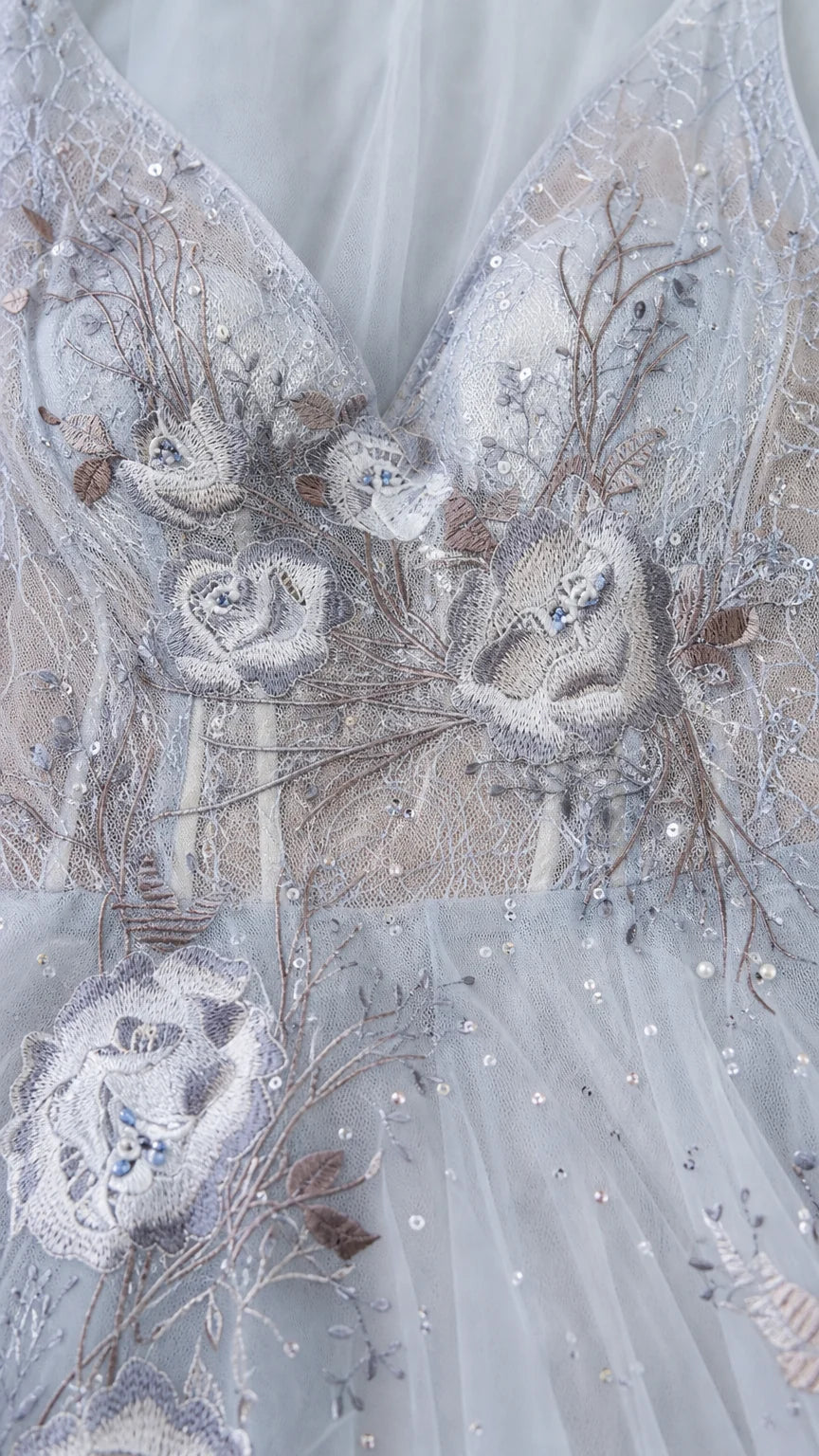 Close-up detail of bodice embroidery and beadwork on light blue gown