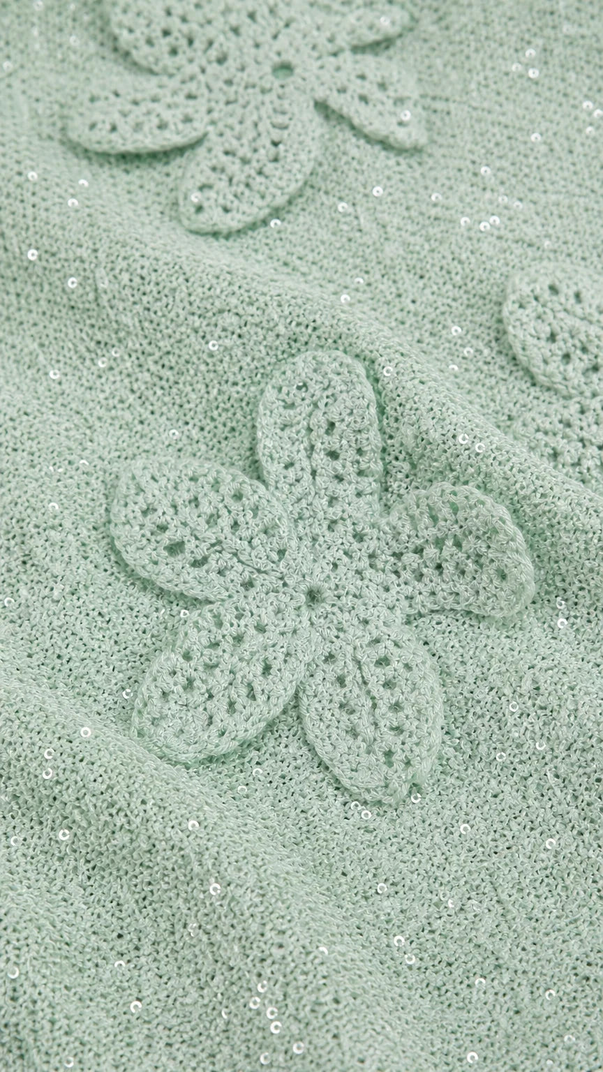 Close-up detail of mint green crochet floral applique and shimmer fabric