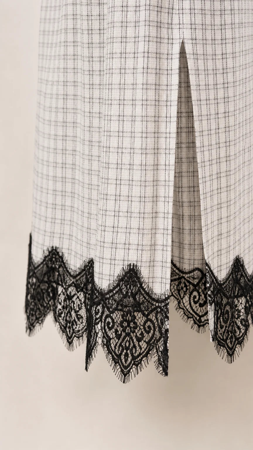 Close-up of lower hem detail showing side slit and scalloped black lace