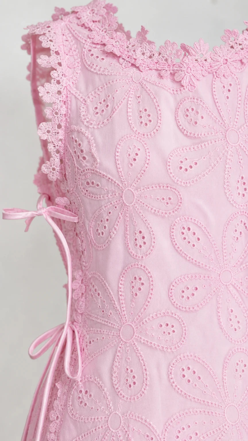 Close-up detail of pink floral eyelet fabric and side tie