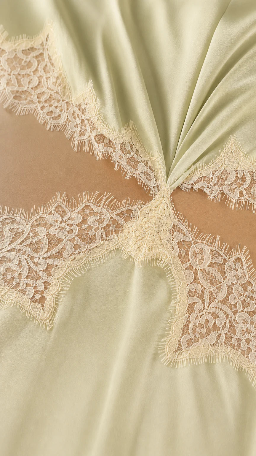 Close-up detail of lace trim and waist cutout on satin dress