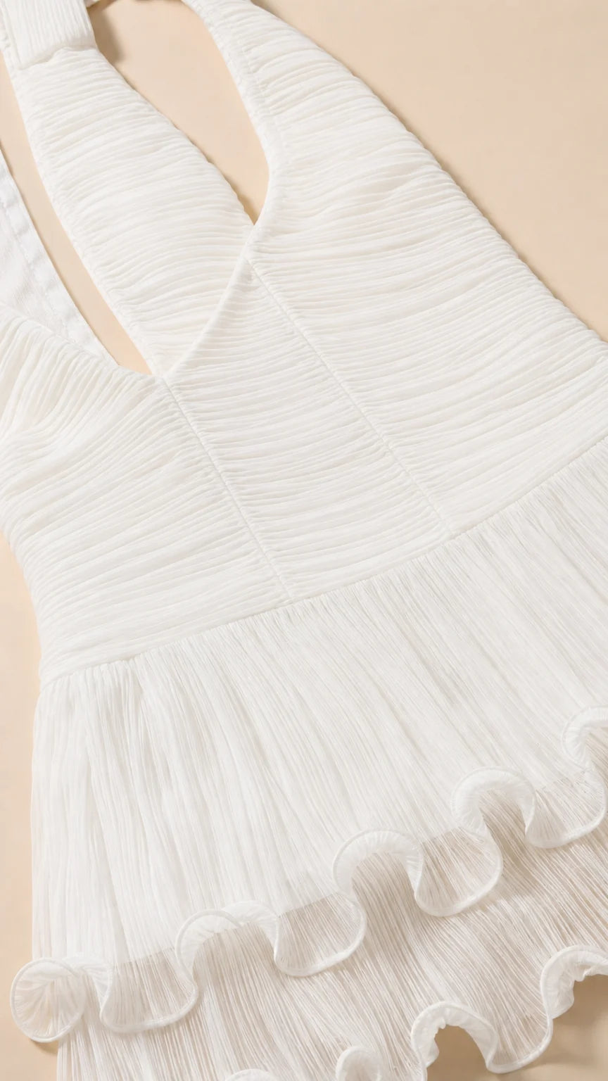 Close-up detail of white textured fabric and ruffle hem