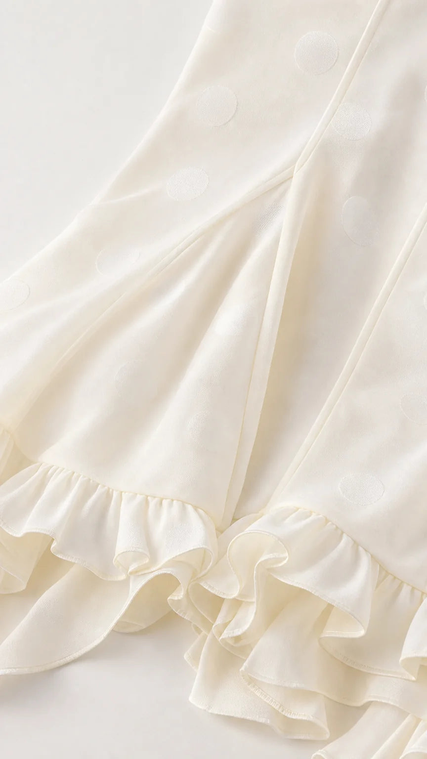 Close-up detail of White dotted fabric and ruffle hem