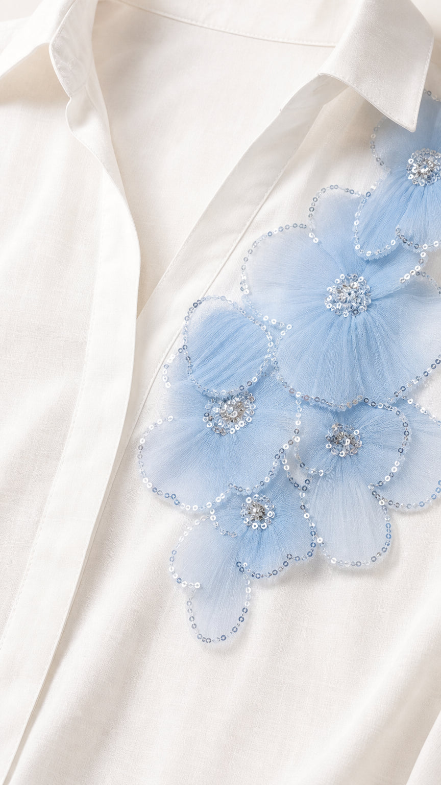 Close-up detail of light blue 3D mesh floral appliqué with sequin and bead embellishments