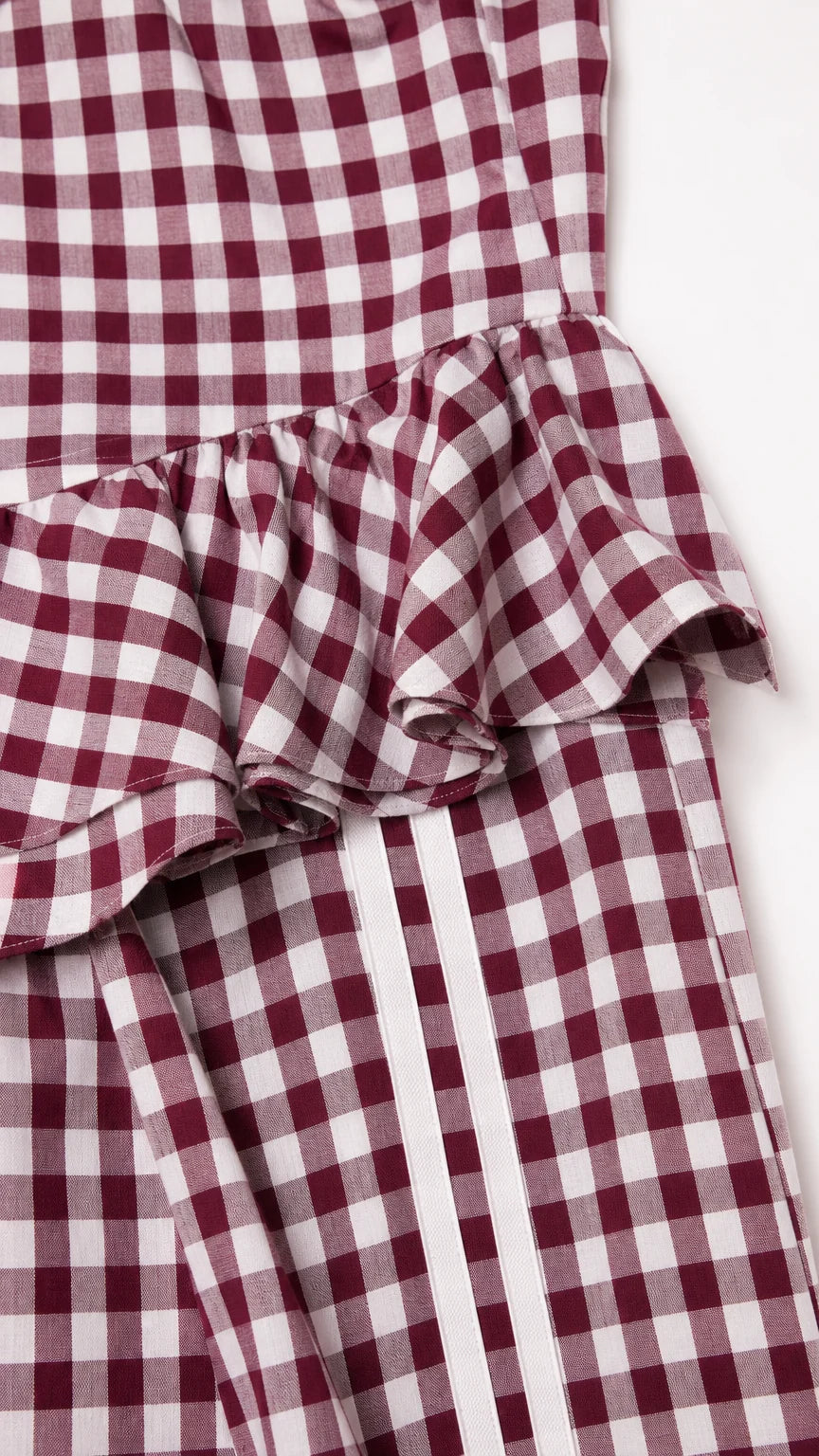 Close-up of peplum ruffle and side stripe detail on burgundy set