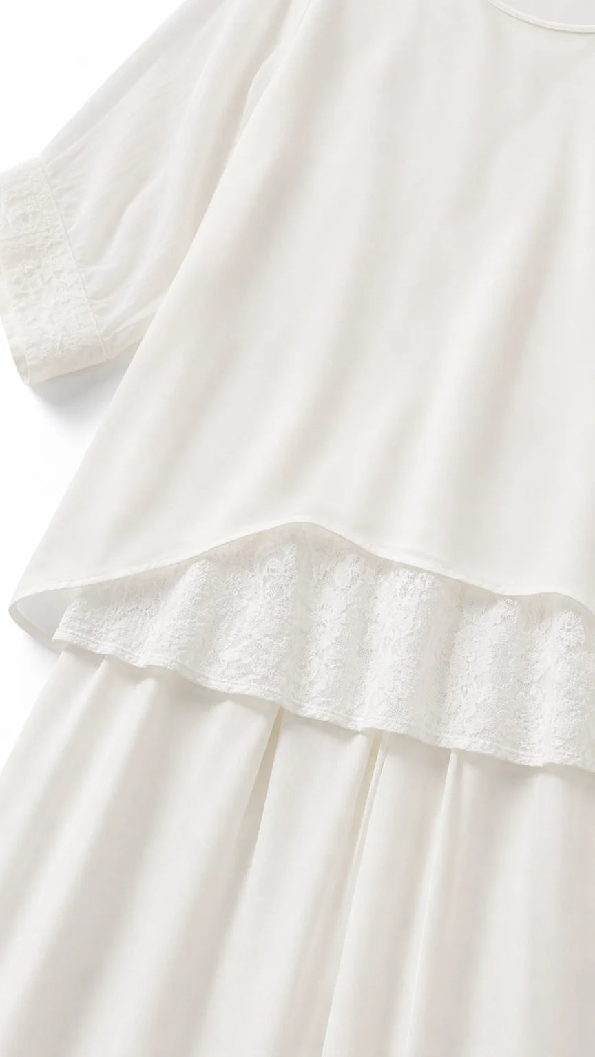 Close-up of white tunic hem with delicate lace trim