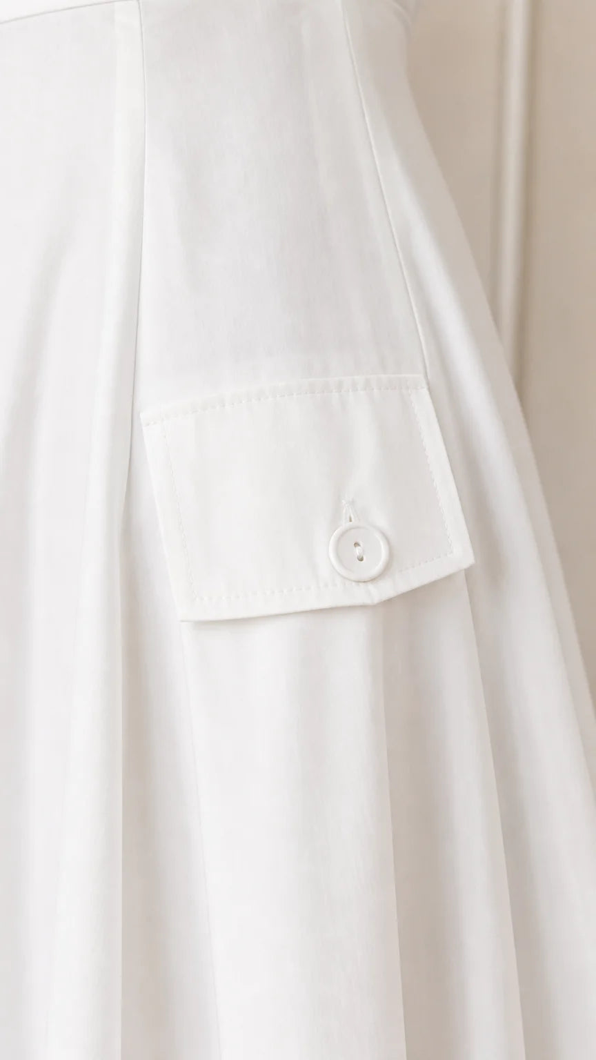 Close-up detail of pocket and button on white dress
