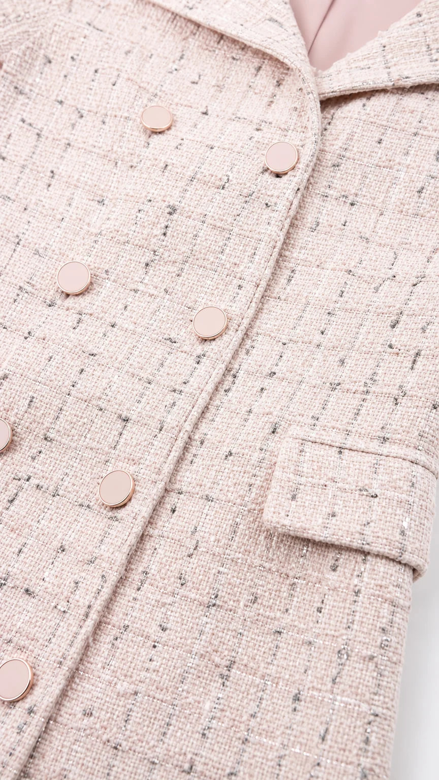 Close-up detail of pink tweed fabric and buttons