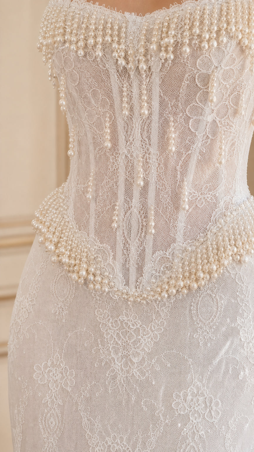 Close-up detail of white corset bodice featuring boning and pearl bead fringe
