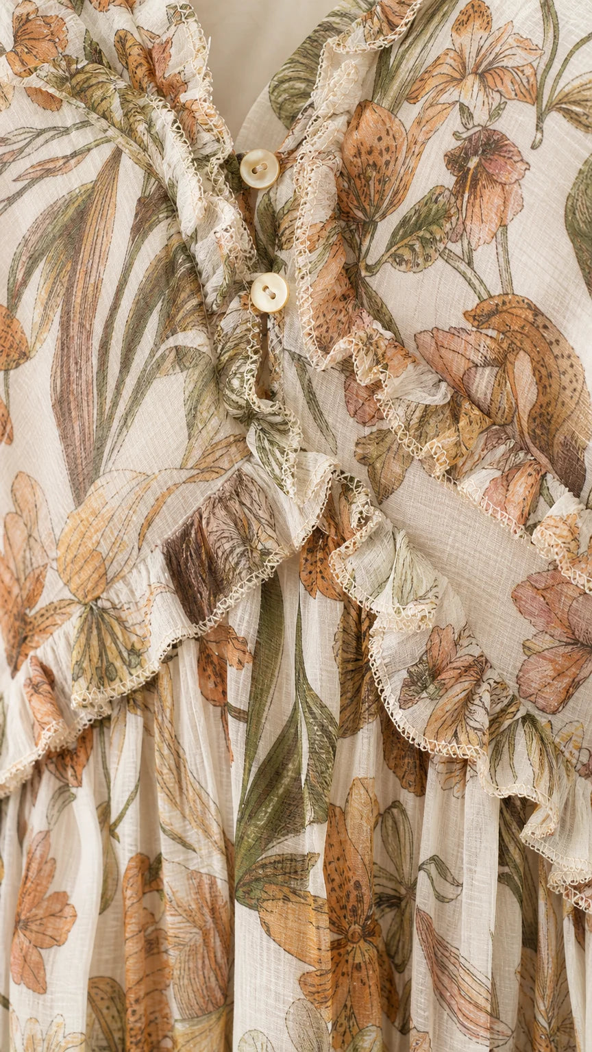 Close-up detail of V-neckline, buttons, and ruffle trim on floral dress