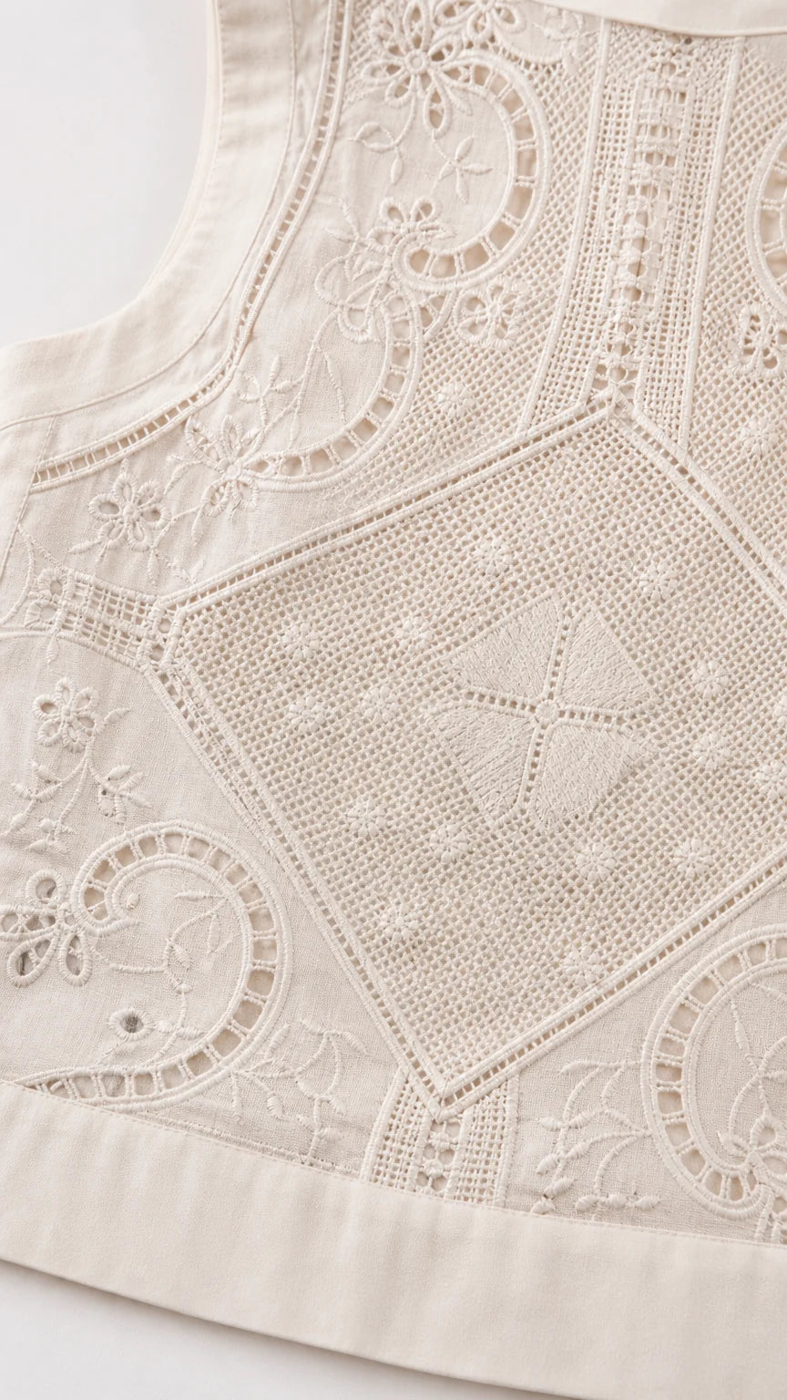 Close-up detail of white embroidered fabric pattern