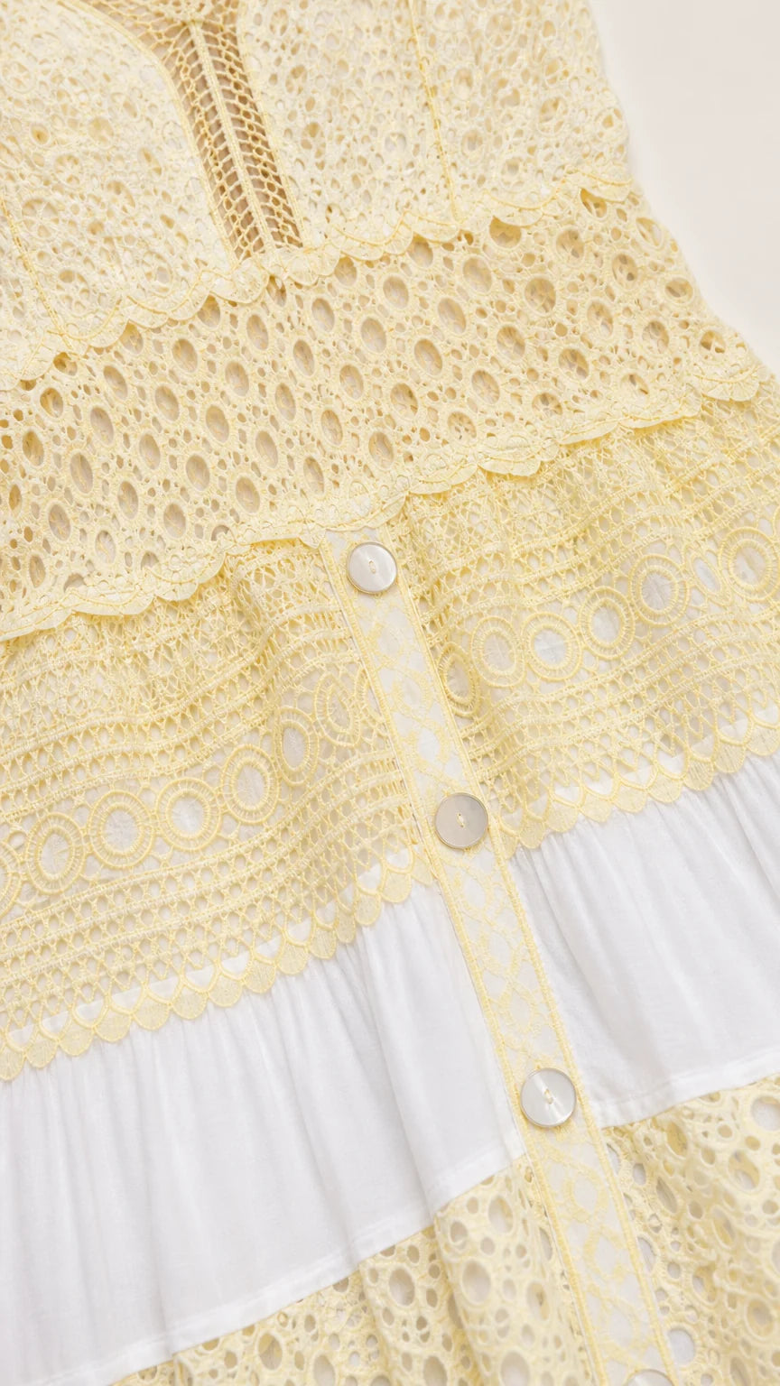 Close-up of crochet and button details on dress