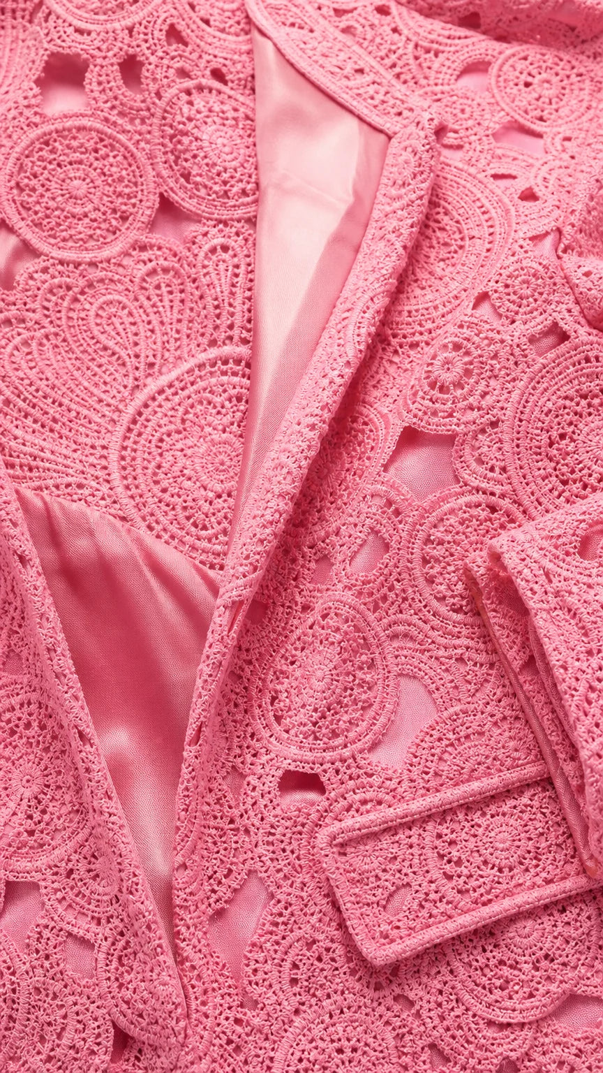 Close-up detail of pink textured lace fabric and satin lining
