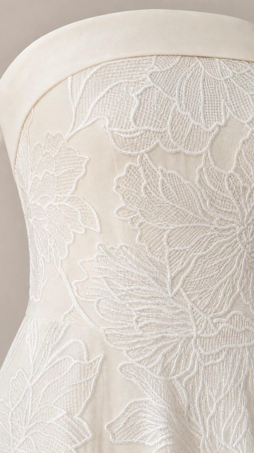Close-up detail of white floral embroidery on strapless dress bodice