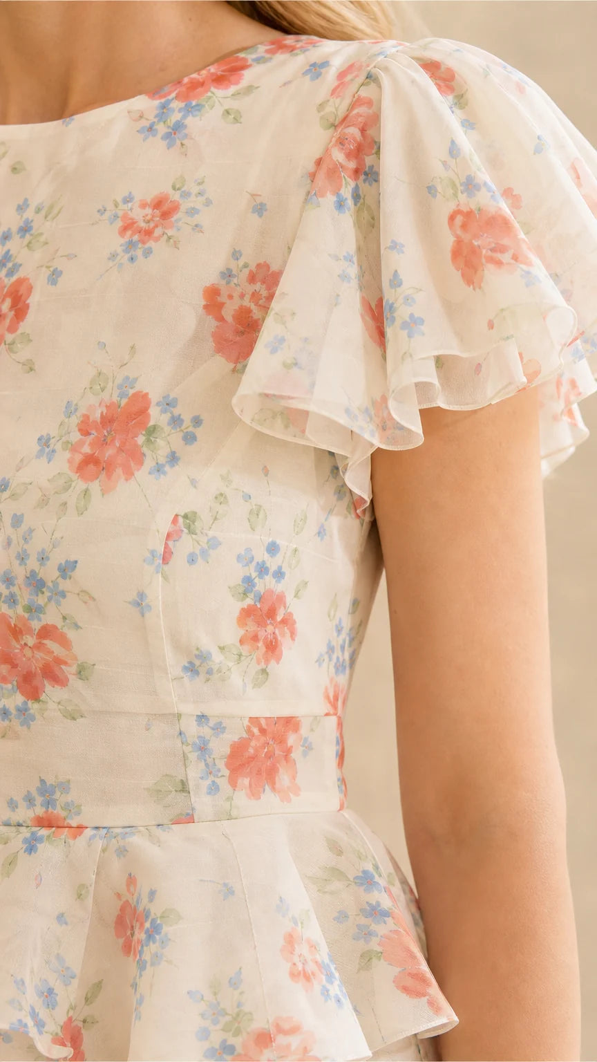 Close-up of ruffle sleeves and bodice on cream floral dress