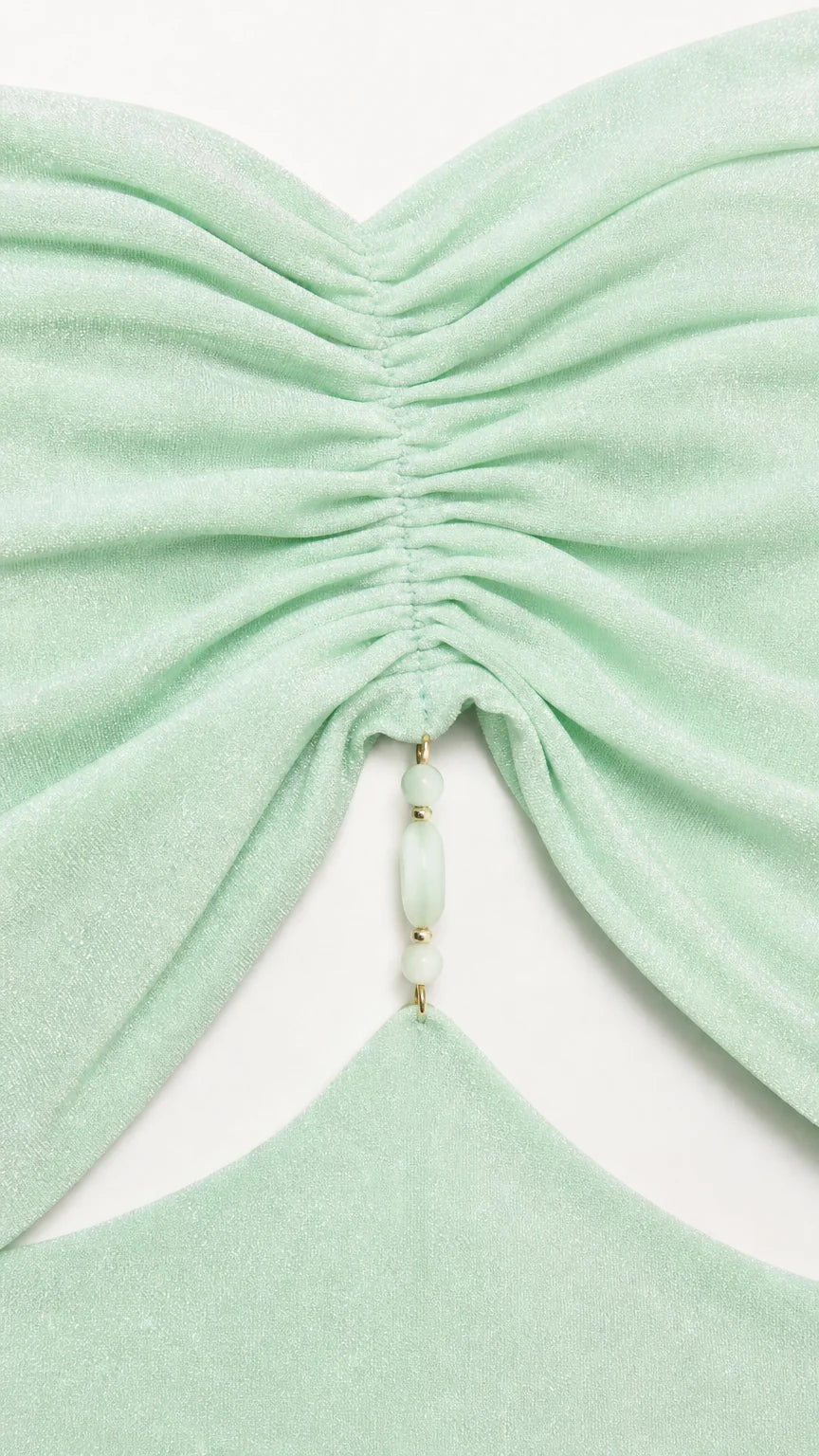 Close-up of ruched bodice and beaded detail on mint green dress