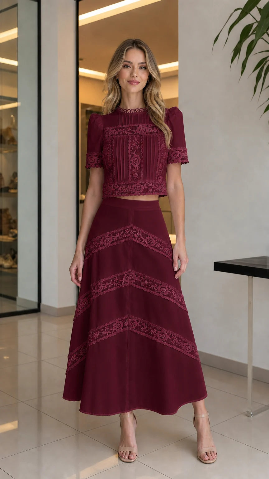 Full-body view of woman wearing burgundy lace crop top and matching skirt set